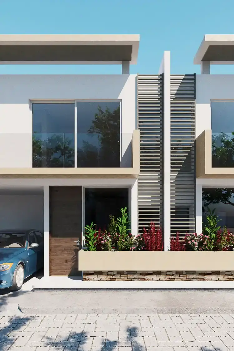 Vista de la fachada de una residencia moderna de dos niveles en Barranquilla, diseñada por Edson Sánchez Arquitecto. Presenta líneas limpias, balcones con barandas de vidrio, ventanales de piso a techo, una jardinera integrada con vegetación de acento sobre un zócalo de piedra, y una pantalla vertical de lamas de madera para privacidad. Un vehículo azul se estaciona a la izquierda sobre pavimentos articulados